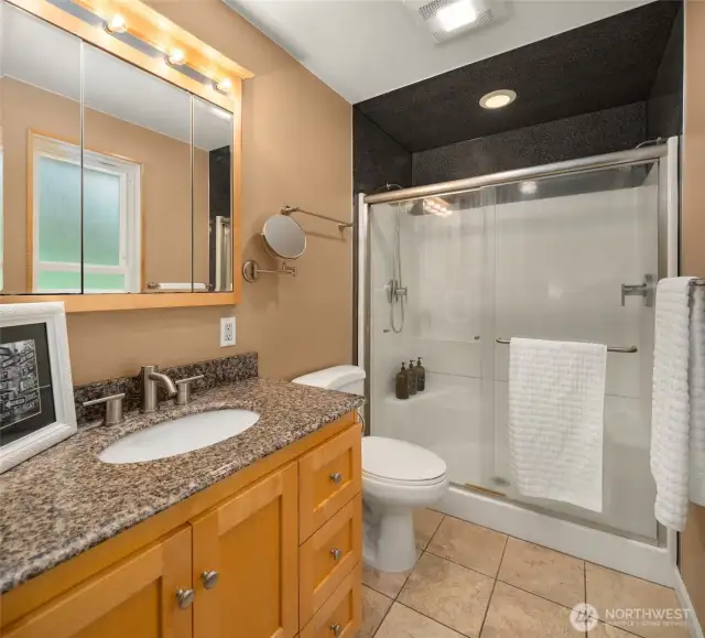Attached bathroom with tile floors, over size shower with dual shower heads and seat.