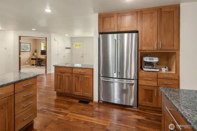 Newer Kitchenaid fridge adjacent to coffee nook or microwave spot.