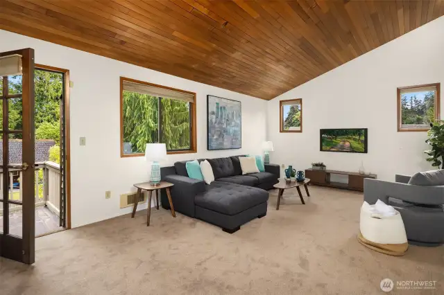 Upstairs family room with vaulted ceiling, and door to the upper deck overlooking the backyard.