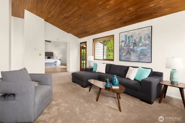 Upstairs family room with vaulted ceiling, and door to the upper deck overlooking the backyard.