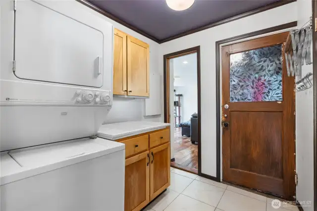 utility room with stackable unit, built-in cabinets and folding space
