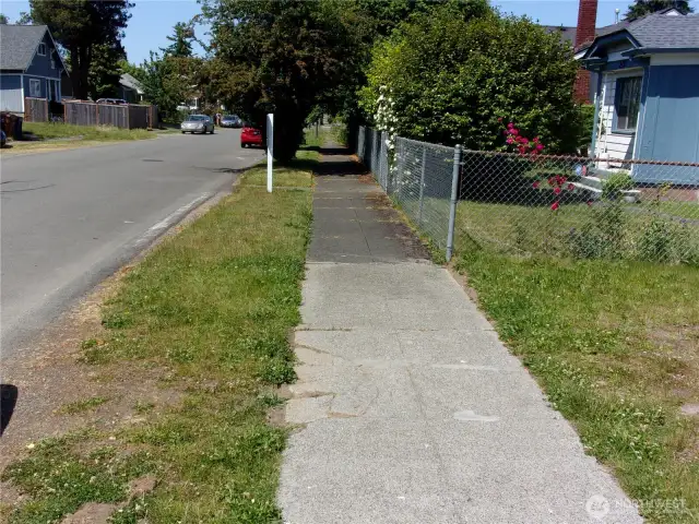 Sidewalk looking north.  Street appears to have been re-paved not long ago.