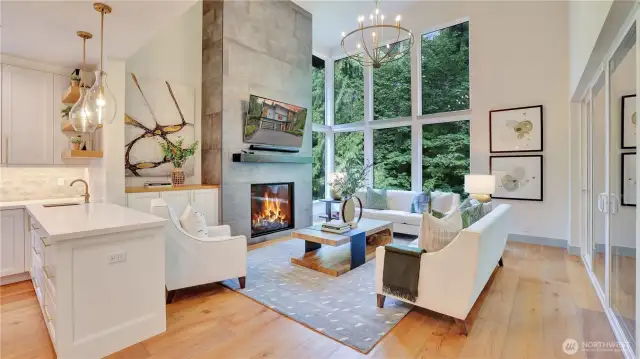 The grand great room welcomes you with soaring ceilings, a striking Italian tile gas fireplace, and expansive walls of windows that bathe the space in natural light. Rich knotty-barrel hardwoods flow throughout the main and upper levels, adding warmth and texture to the modern aesthetic.
