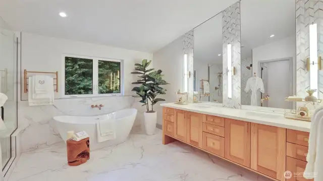 The spa-inspired bath includes dual vanities, a freestanding soaking tub, spacious shower, heated towel bar and floors, enhanced by ambient lighting.