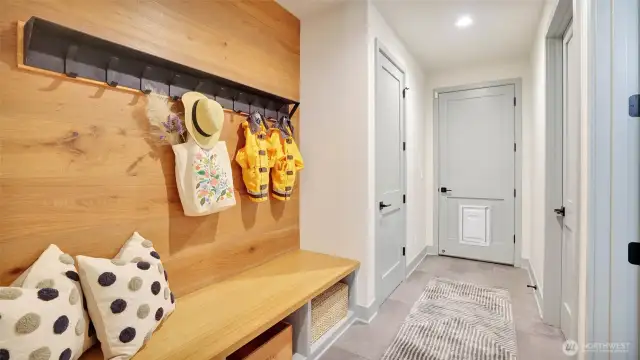 Mud room with bench, cubbies and hooks for clothing at the garage entry, enhances everyday living.
