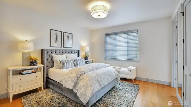 Upper level en-suite bedroom with organized closet and custom blinds.