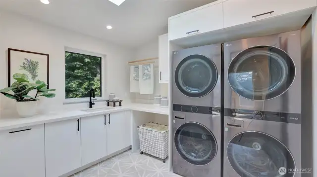Dual washers and dryers make laundry a breeze. The window and whimsical tile floors are a thoughtful addition.