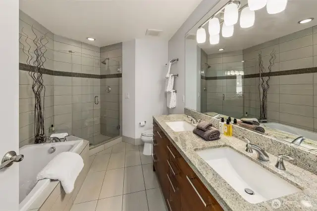 double vanity, frame less glass shower, over sized soaking tub with full height stone wall finish
