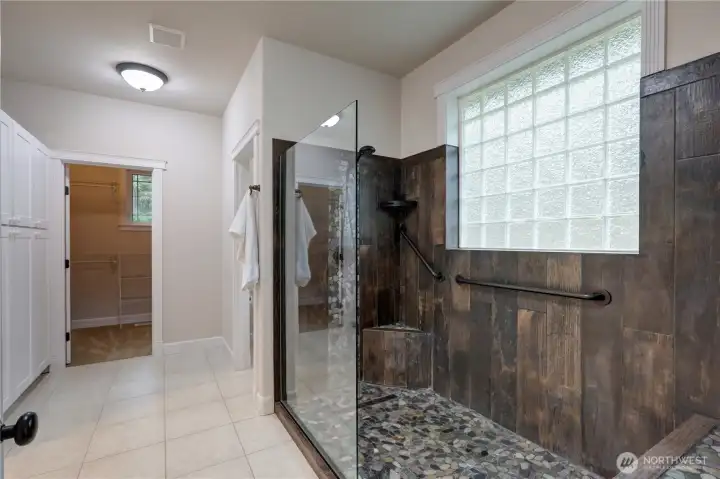 Custom walk-in shower with glass block window. Large linen on the left.