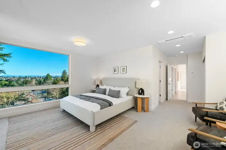 Primary bedroom with corner windows framing big mountain views.