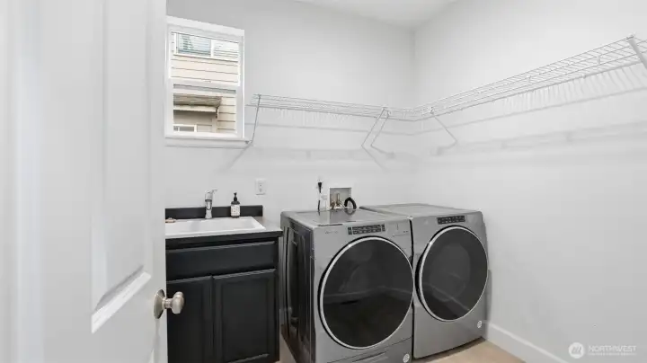 Well-appointed laundry room with ample shelving.