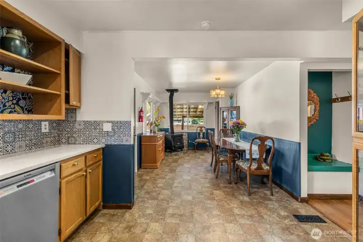 Kitchen w/ abundant natural light opens to dining area with wood stove