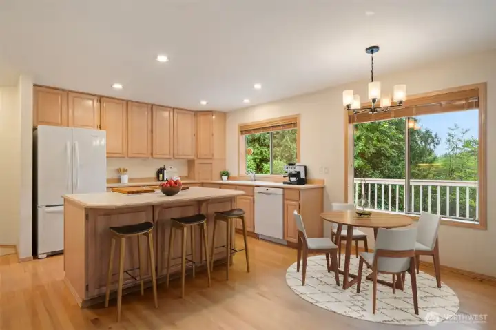 Open Air Kitchen with center island & bar stool area, eat in kitchen, wood floors & cabinets, open to family room with slider to large entertainment size deck & trails below. Virtually staged to show you size and potential!