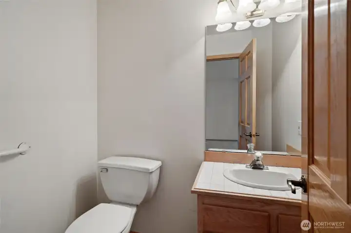 Half Bathroom of Family Room - Easy access to Kitchen, Deck & Garage. Wood flooring.