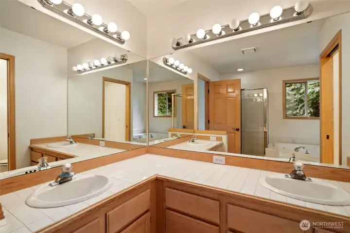 Primary bathroom with separate vanities and sinks.