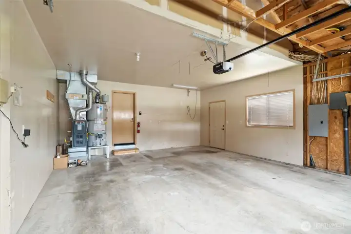 Generous garage with newer heater and hot water heater. New garage door opener -plenty of room for storage cabinets and work bench.