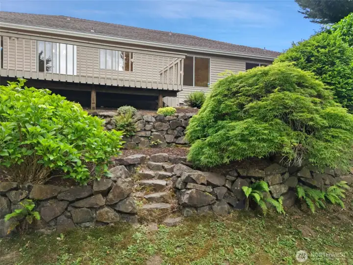 Back yard view of home and steps leading to deck