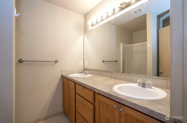 The private primary suite bath features dual sinks and a walk-in shower.