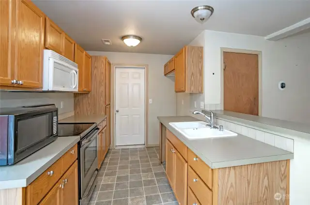 The kitchen is thoughtfully positioned to allow easy conversation with guests in both the dining and living areas.