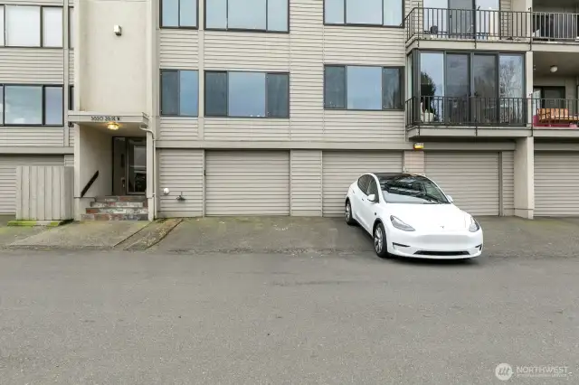 One of two entrances to the building.  This entrance is closest to unit 102 with a two car tandem garage behind the Tesla as well as additional storage in the garage.