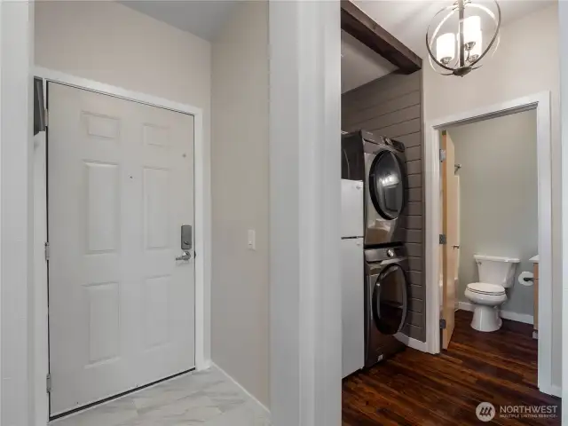 Then entry opens to the unit with tile floor. On the left is the utility area and on the right is the secondary bedroom.