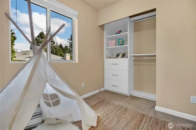 The bedroom offers a closet system for added storage. The doors are stored in the garage.