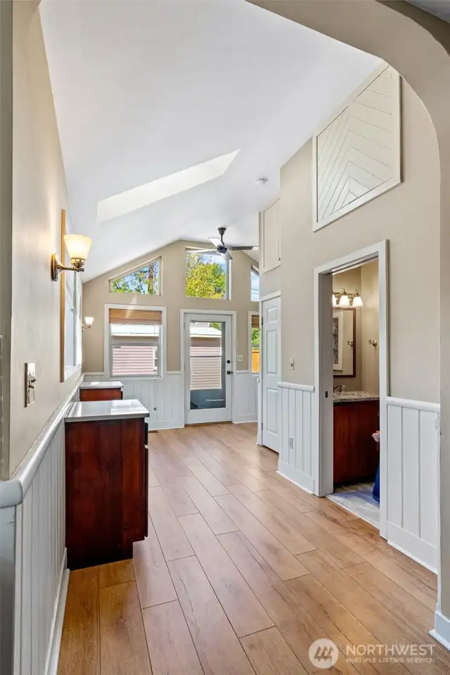 1/2 bath, storage and bench and back door, around the corner is the stairs going to the basement.