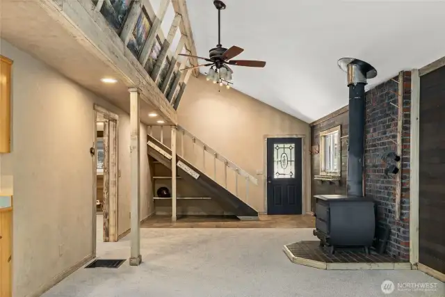 Living room with a wood burning stove, notice the helmet underneath the stairs?  Great storage for your winter gear!