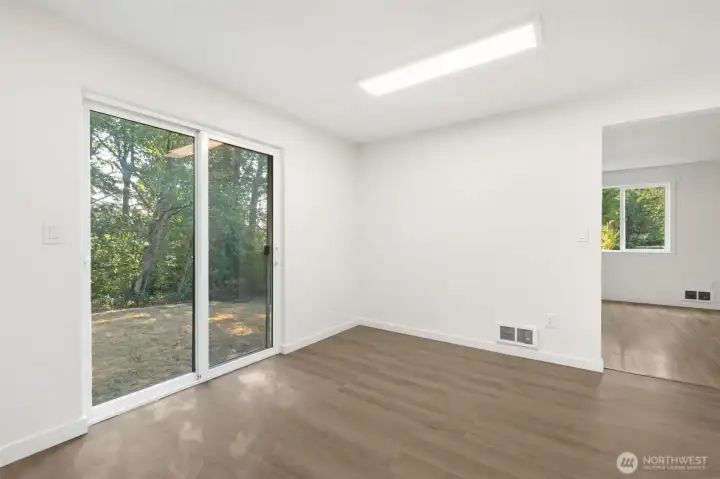 Large, open dining space in kitchen with sliding glass door to backyard.