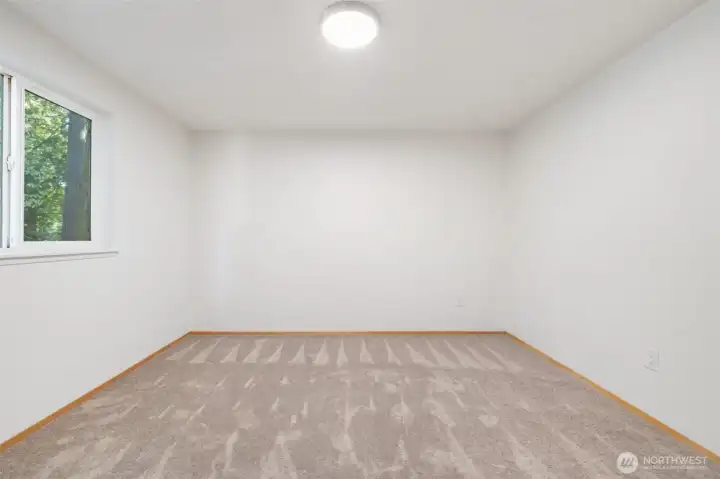 Primary bedroom has new carpet and light fixture.