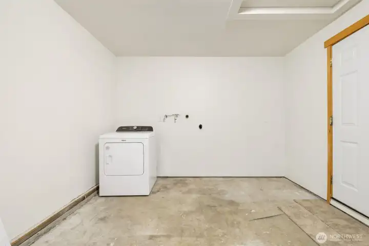 Freshly painted garage with new garage door opener, exterior key pad access, and new water valves for washing machine.