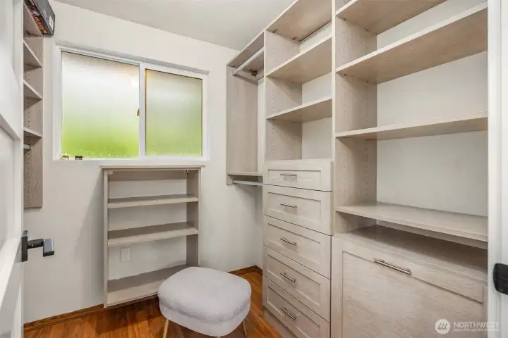 The primary bedroom walk-in closet features a new California Closets system with built-in laundry basket.