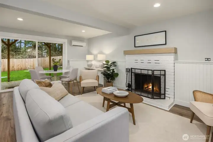 The bright lower level bonus room features a second wood burning fireplace, and new sliding glass door that steps out to the level back yard.