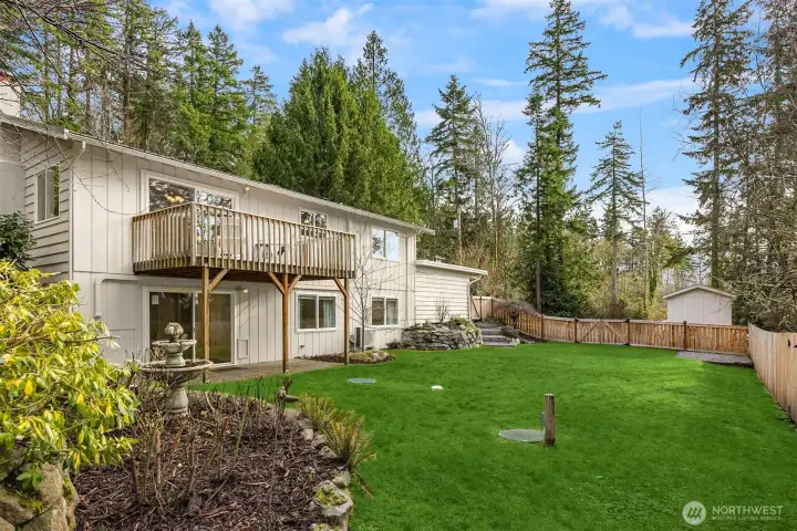 This view showcases the expansive fenced-in backyard with terraced gardens.