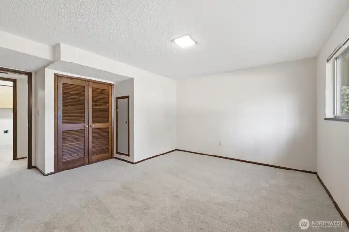 2nd photo of lower large bedroom standing in front of built ins.