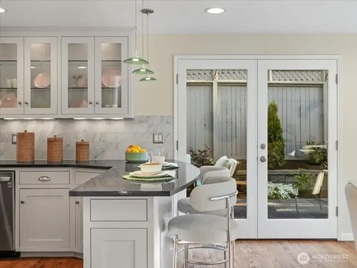 The eat-in kitchen opens through French doors for effortless indoor-outdoor living—perfect for dining alfresco.