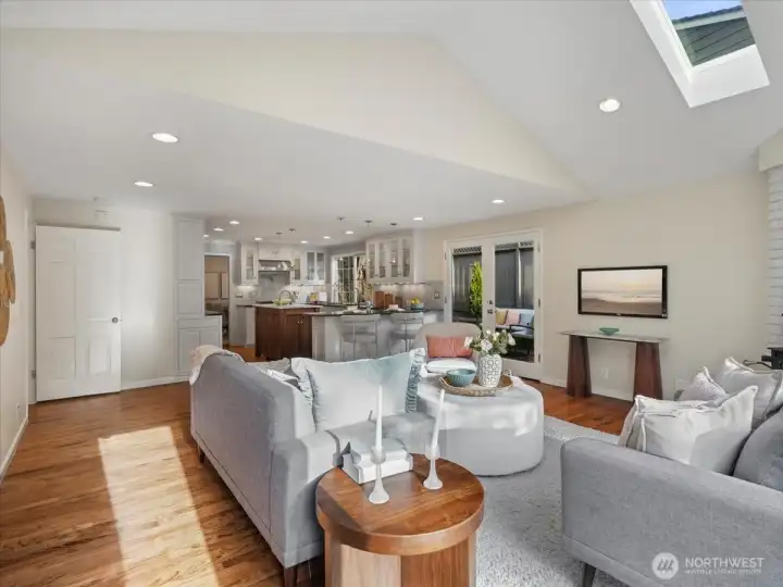 The spacious family room is filled with natural light, with vaulted ceilings and skylights above creating an open, airy feel.