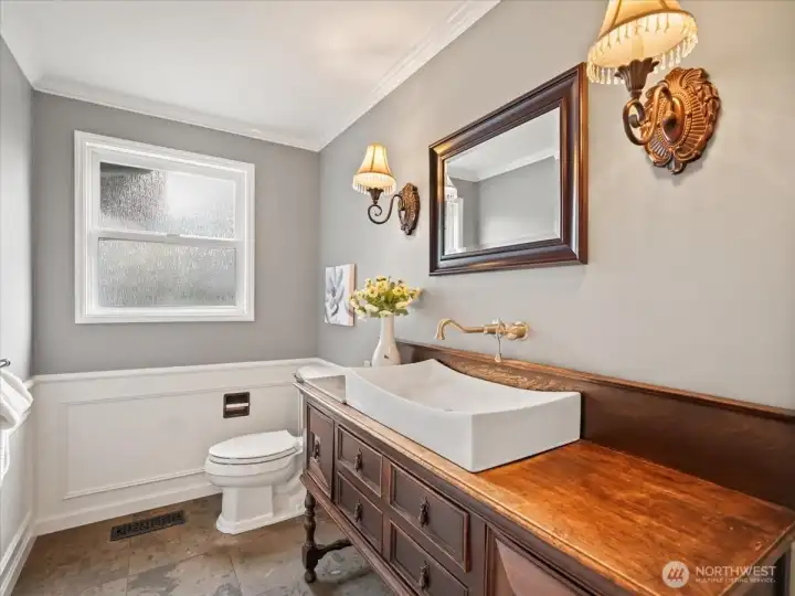 The main floor bath features a beautiful antique sink, designer fixtures, and a slate floor for a distinctive, timeless feel.