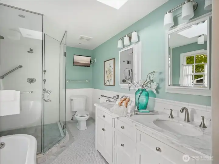 The primary bath features a separate shower and soaking tub, double sinks, and custom tile and marble throughout.