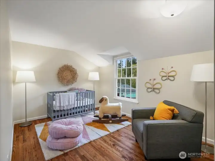 Bedroom two continues the hardwood floors found throughout the home and offers lovely treetop views through the window.