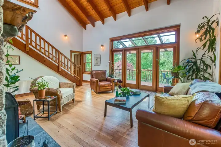 Living room with stone fireplace and French doors to the front deck.