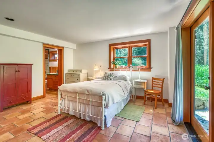 Lower level bedroom could serve as a primary suite with spacious sitting room and French doors to the outdoor patio and grounds.