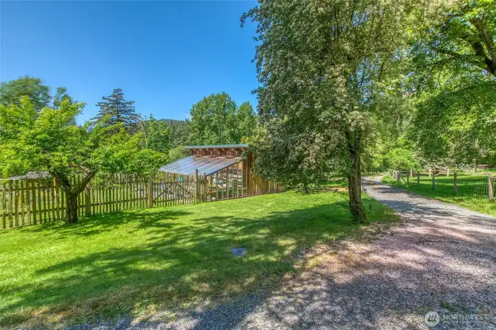 The greenhouse and shop are located near the barn, not far from the main home.