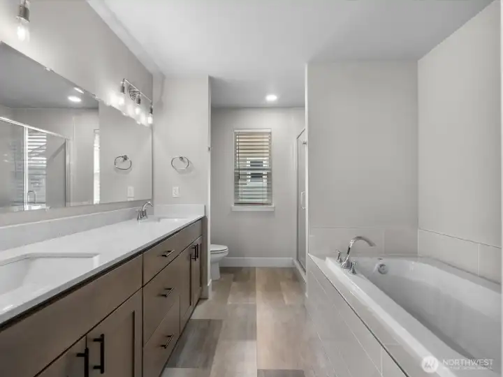 Primary suite 5 piece bath w/ dual sinks, tub, shower, etc. Ceramic tile floors. Quartz countertops.