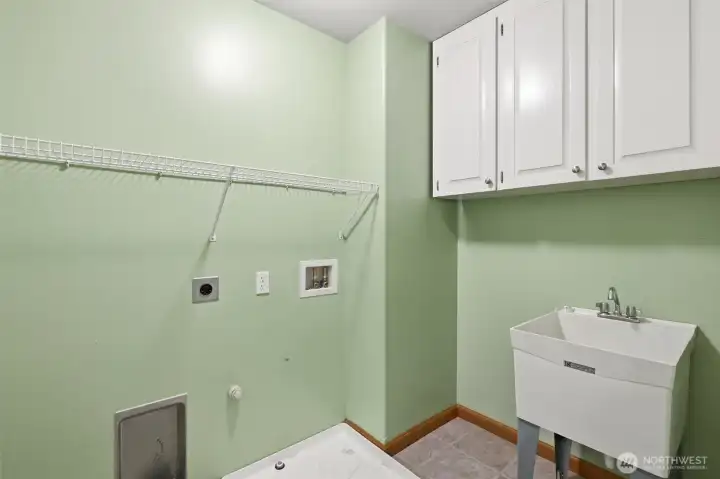 Upstairs laundry room with utility sink and extra storage.