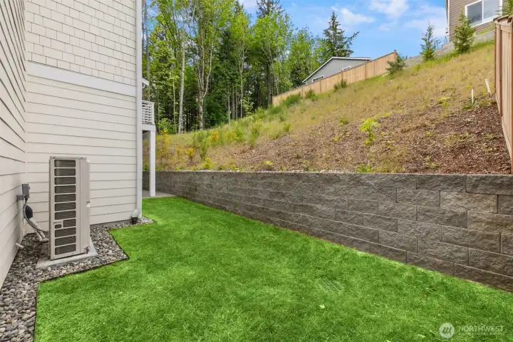 Small side yard, with already installed sprinklers up hillside for future landscaping.