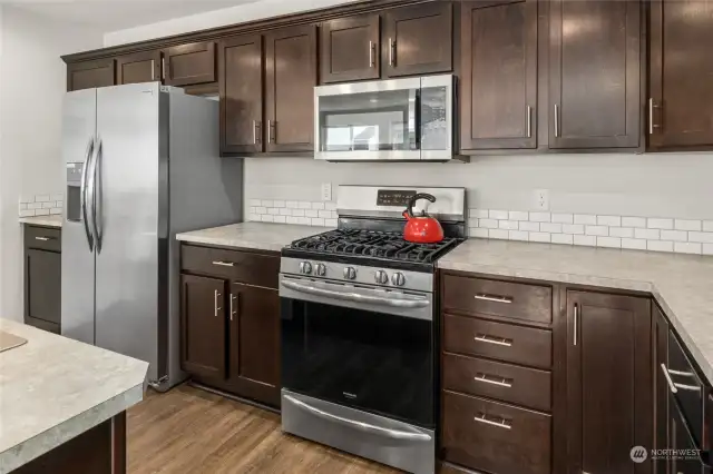 Stainless steel appliances pair nicely with the countertops and flooring.