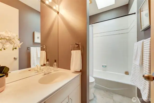 Guest bath with skylight and gorgeous travertine tile.