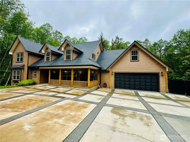145 Scenic Lane with covered front porch and covered deck provide a the PNW feel with sounds of the creek and lushes evergreens skirting the grounds.
