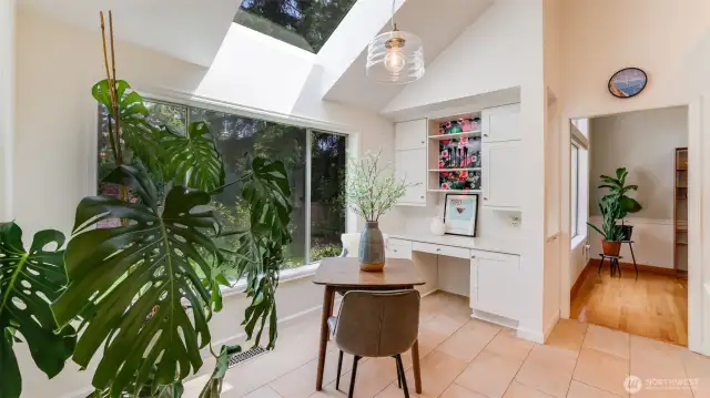 This versatile space is perfect for a secondary dining area or a cozy drink bar nook. Framed by wall-to-wall windows and a large overhead skylight, it’s drenched in natural light and features built-in shelving for extra storage and elegant tile flooring